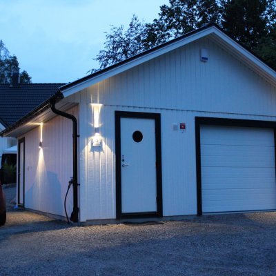 Vitt garage med trevlig fasadbelysning