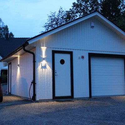 Vitt garage med trevlig fasadbelysning