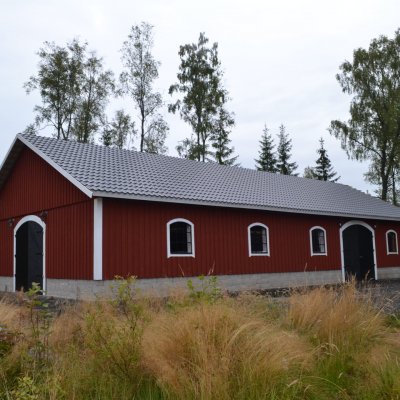 Stallbyggnad med välvda fönster och portar